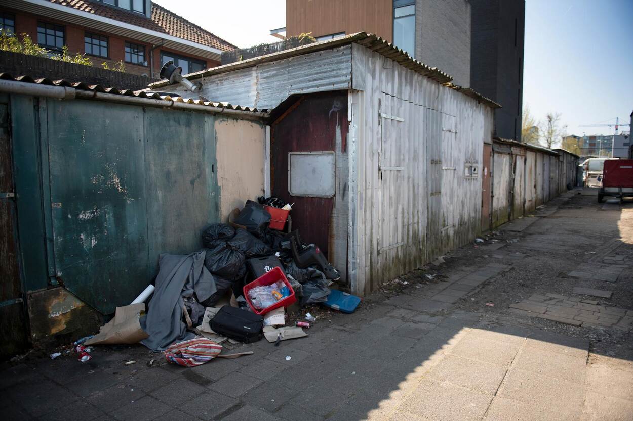 Op deze foto zie je een woning met veel afval ernaast. Het is een voorbeeld van verloedering.